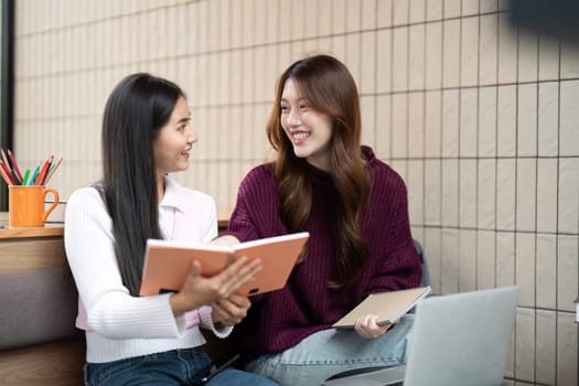 In a cozy study space, two friends engage in a lively discussion about their school notes, fostering collaboration and academic success.