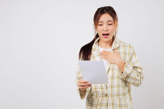 Asian woman appears shocked while reading bills, facing real financial problems and preparing for deeper financial struggles with debt and budgeting issues. isolated studio white background
