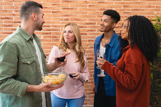 Diverse group of friends gathered around a table, smiling and chatting during a cozy dinner at home. Warm atmosphere, good food, and laughter define this moment of connection and friendship.