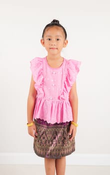Portrait of Thailand kid girl smiling traditional Thai dress costume in studio shot isolated white background, Happy Portrait kindergarten little woman stand and looking to camera