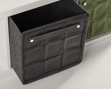 Stylish black leather storage box with handle being pulled out of a white drawer