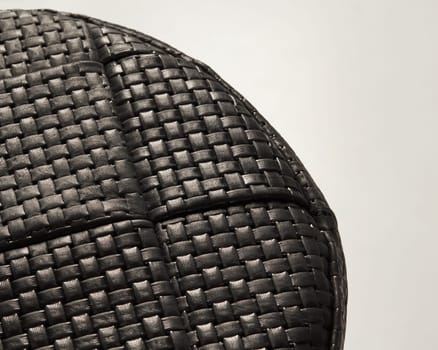 Intricate woven pattern of black leather creates a textured and stylish surface