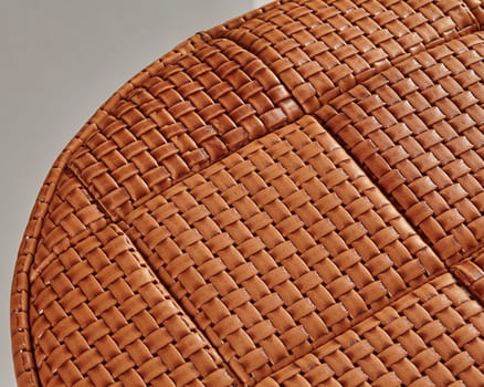 Intricate woven leather upholstery adds a touch of elegance and texture to a round piece of furniture