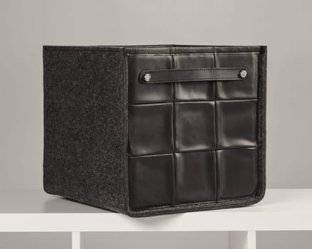 Stylish storage box combining black leather and gray felt, ideal for organizing belongings