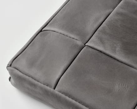 Gray leather surface with visible stitching and texture, suggesting high-quality craftsmanship