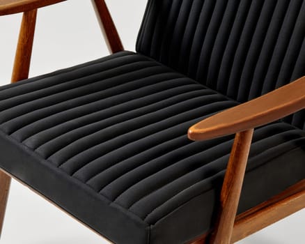 Comfortable lounge chair with black ribbed upholstery and wooden frame, ideal for modern interiors seeking relaxation and style