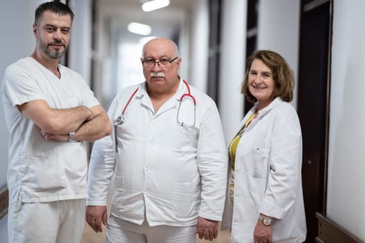 A team of experienced doctors standing in the hospital hallway, weary but dedicated after a long day of caring for patients