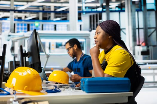 Solar panels factory engineer optimizing production flow on desktop setup, assembly line. Sustainable energy plant specialist monitoring manufacturing process, photovoltaic system.