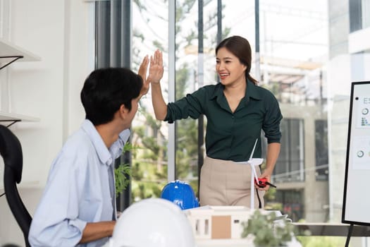 A woman and a man celebrate teamwork with a high-five, showcasing collaboration in renewable energy solutions.