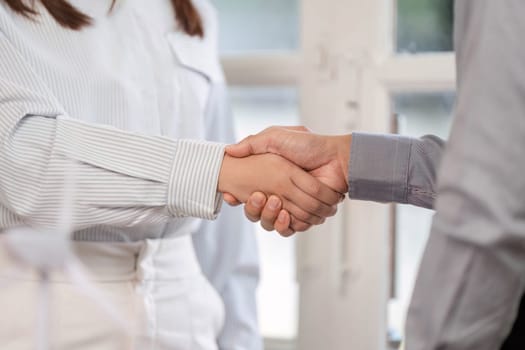 A close-up view of a handshake, representing a business agreement and mutual trust between colleagues.