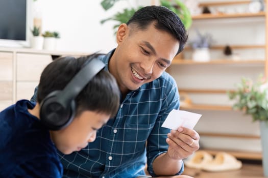 The father and son share a moment of creativity as they explore school materials together, highlighting the joy of learning in a supportive home environment.