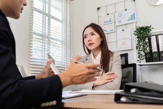 A focused financial advisor engages with a client, sharing insights and strategies in a modern office setting.