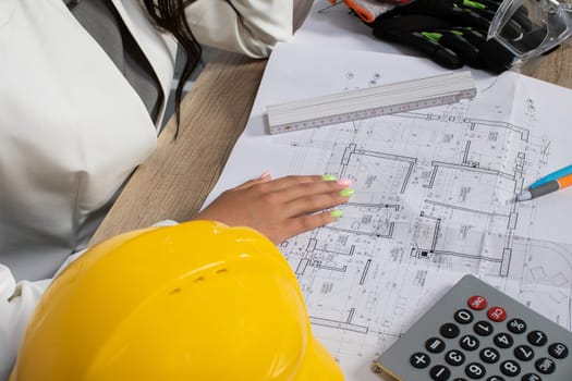 A worker analyzes blueprints and data for a construction project, emphasizing teamwork and strategy.