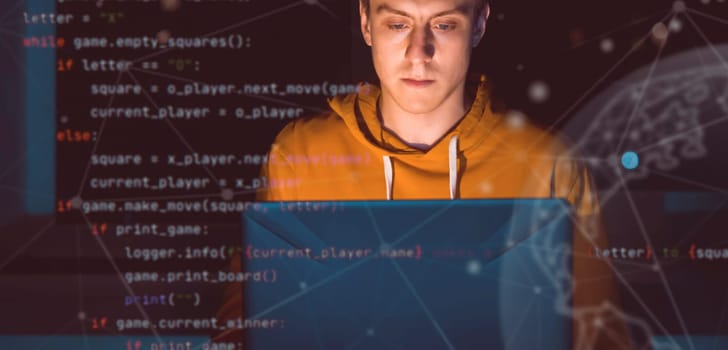 A young man works online at night on a laptop, plans the development of his business, signs and symbols of the global network, planet and diagrams are added on the photo.