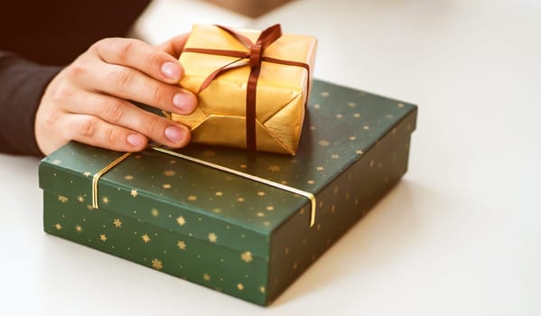 Male hands hold gifts in beautiful wrapping paper closeup view, a man prepares gifts for his loved one, relatives, friends and family for celebration the holiday.