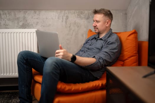 Handsome Man Sitting In Chair With Laptop At Home