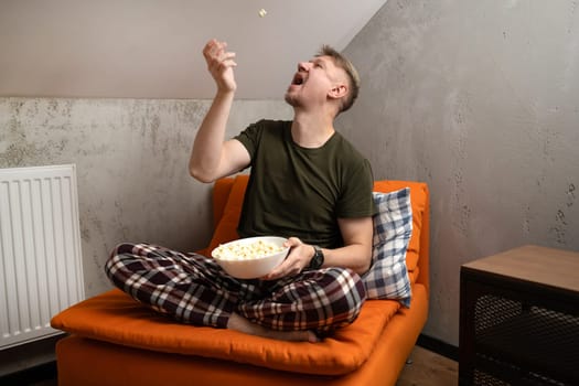 Man Playing With Popcorn At Home In A Chair