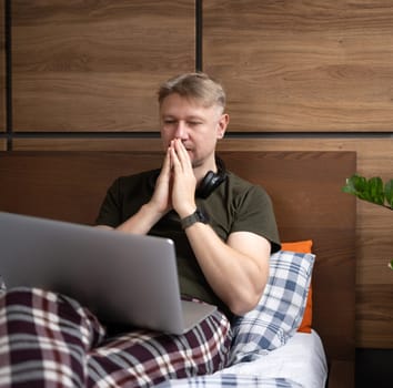 Excited Man Using Laptop In Bed At Home