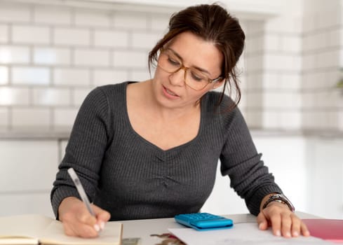Young Woman Sorts Out Finances At Home Table