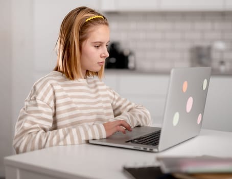 Cute Little Girl Using A Laptop At Home And Browsing The Internet And Social Media