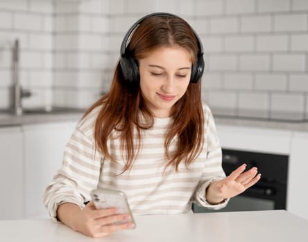 Girl In Headphones Listening To Music Through A Smartphone