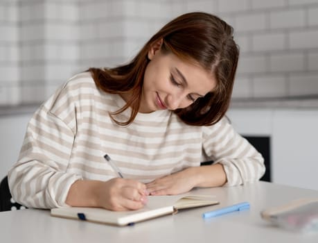 Teen Girl Thinking While Sitting Over Notes At Home