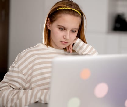 Cute Little Girl Using A Laptop At Home To Surf The Internet And Social Media