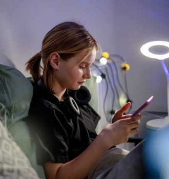 Cute Little Girl Chatting On Social Media With Smartphone In Bed Before Sleep