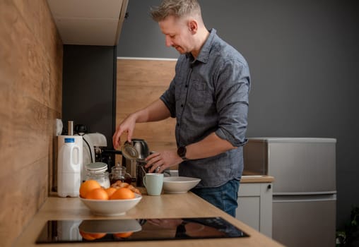 Man Making Coffee For Himself In The Kitchen In The Morning