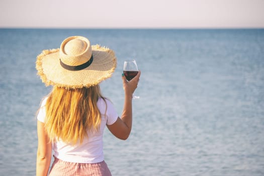 Girl with a glass of wine against the sea background