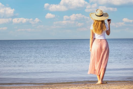 Girl with a glass of wine against the sea background
