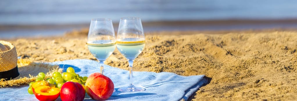 Two glasses of wine and fruit against the sea background