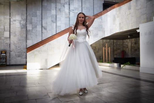 A radiant bride in a stunning gown is elegantly poised at a contemporary venue, showcasing joy and love during her wedding registration.
