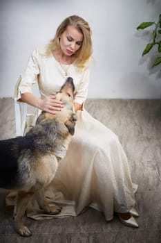 A middle-aged woman enjoys quality time with her German shepherd in a cozy indoor setting, showcasing their bond.