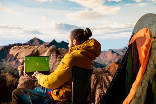 Trekker takes in the panoramic landscape next to isolated mockup screen, where the peaceful mountain scenery and open sky symbolize adventure and perseverance. Wanderlust with tech.