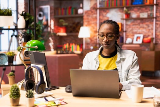 Remote worker in home office typing on laptop keyboard, preparing presentation slides, adjusting layouts. Freelancer finishing company project, writing summaries, saving files on notebook