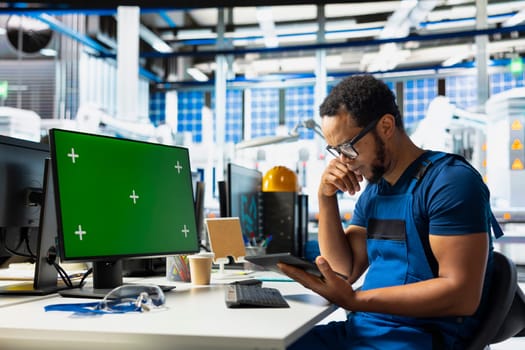 Manufacturing plant employee reviews data on green screen pc to improve the production line, eco friendly solar power. Solar panels factory technician identifying system errors using mockup.