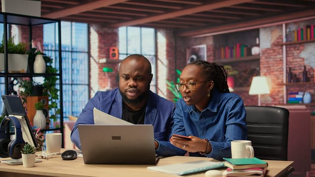 Relaxed people entering card numbers to verify the balance before paying online, e commerce on webpages at home. Couple making web transactions and transferring money. Shopping. Camera A.