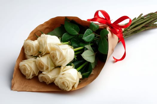 Creamy white roses wrapped in rustic kraft paper with vibrant greenery, tied elegantly with a red ribbon, offering understated sophistication and grace, isolated transparent background..