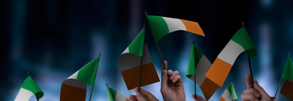 Ireland flags in their hands on a blurred urban background. The photo illustration was created without the use of artificial intelligence, only using Photoshop.
