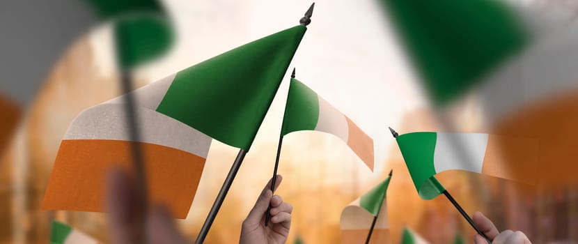 Ireland flags in their hands on a blurred urban background. The photo illustration was created without the use of artificial intelligence, only using Photoshop.