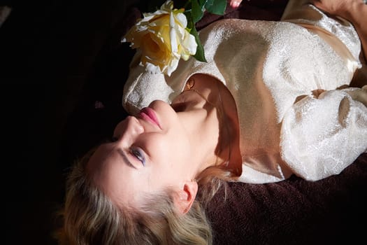 A woman with blonde hair captures a serene moment while posing with a flower, showcasing her lifestyle blog theme.
