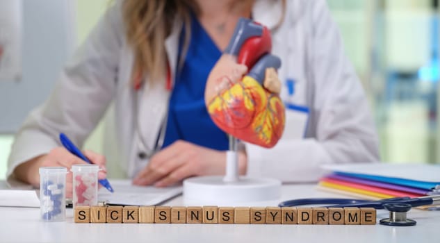 A healthcare professional examines sick sinus syndrome with a heart model, emphasizing cardiac health.
