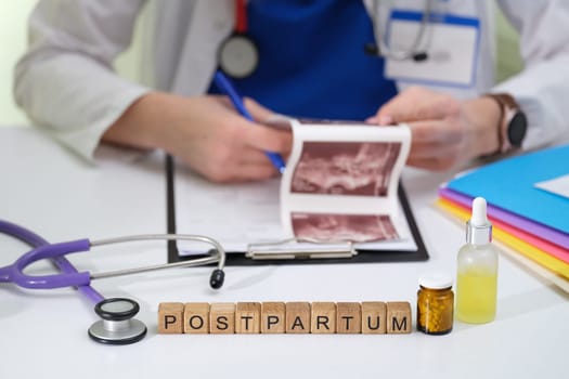 A healthcare professional reviews postpartum ultrasound images surrounded by medical tools and equipment