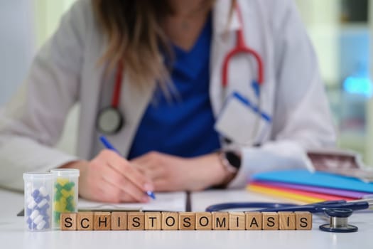 A healthcare professional writes detailed notes on schistosomiasis, highlighting its critical importance in medicine
