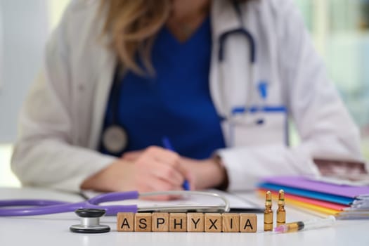 A qualified medical professional discusses asphyxia using various tools and taking notes in a clinical setting