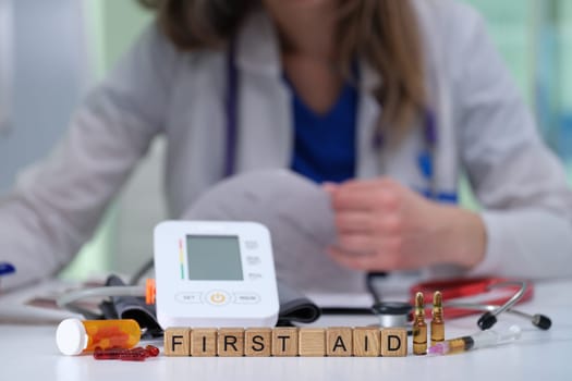 On a medical table, theres a collection of essential first aid tools and an automated blood pressure monitor