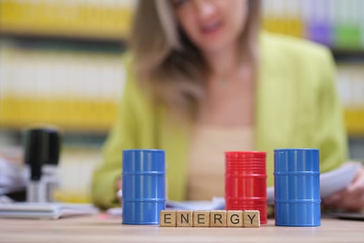 A vibrant scene featuring colorful barrels symbolizing energy, with Scrabble letters spelling 'ENERGY'.