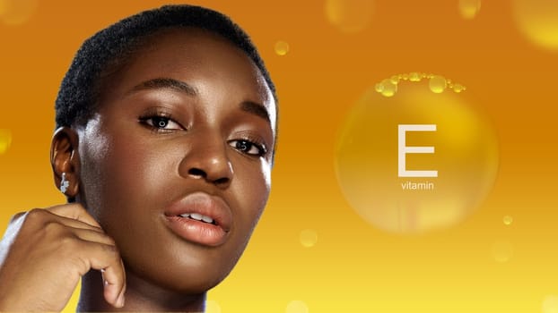 A young woman with short dark hair poses gracefully, showcasing radiant skin against a warm orange backdrop featuring Vitamin E. The lighting highlights her natural beauty and confidence.