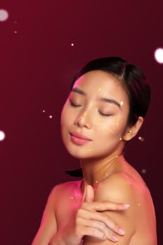 A woman poses gracefully with her eyes closed, showcasing radiant skin adorned with a creative constellation pattern. The vibrant red background enhances the artwork, celebrating beauty.